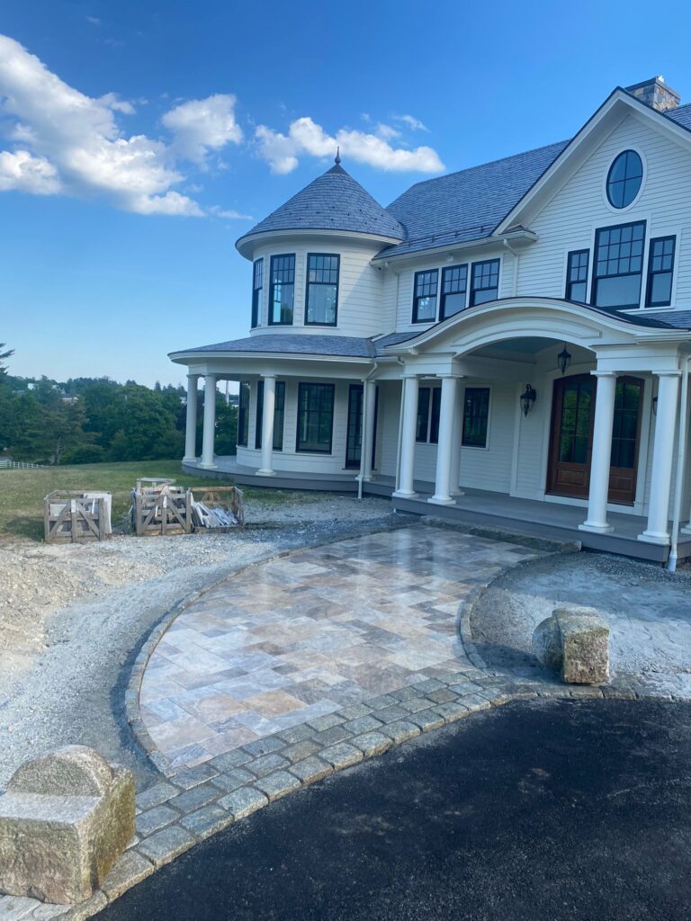 Elegant driveway and walkway installation in front of a luxury home by Marcelino Hardscaping. Serving Central Massachusetts, the Metrowest region, and parts of Greater Boston.